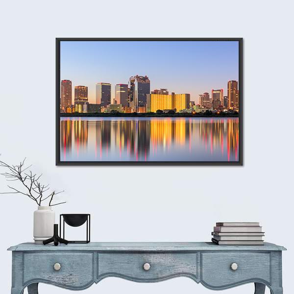City Skyline at Dusk with Water Reflection Canvas Wall Art in orange, yellow and blue, framed canvas, product view on a white background