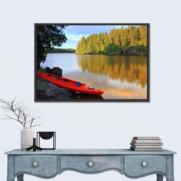 Red Canoe on Rocky Lakeshore at Sunset Canvas Wall Art in orange, yellow and green, framed canvas, product view on a white background