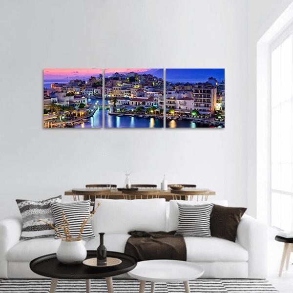 Agios Nikolaos Harbor at Dusk Panoramic Canvas Wall Art in blue, purple and pink, hung on a wall