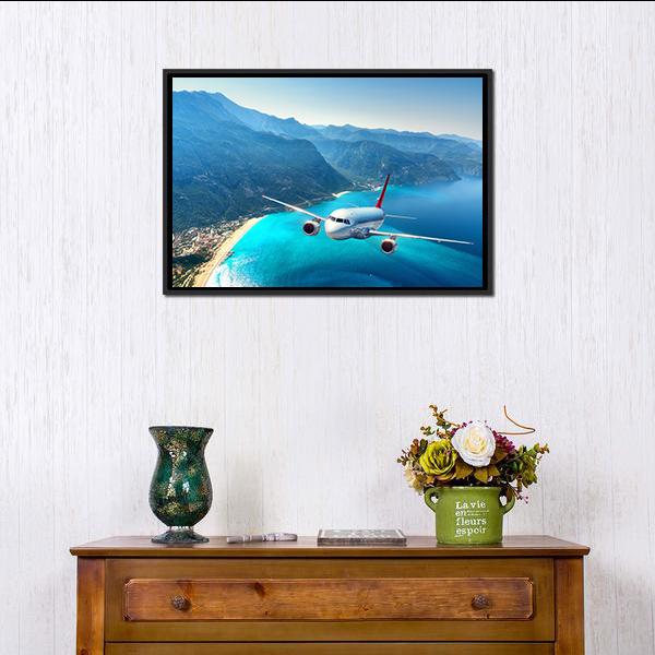 Commercial Airplane Over Ocean Coastline Canvas Wall Art in white, green and blue, framed canvas, product view on a white background