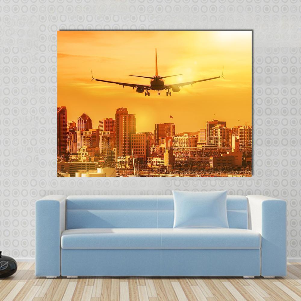 Airplane Flying Towards City Skyline Canvas Wall Art in brown, orange and yellow, single panel hung on a wall