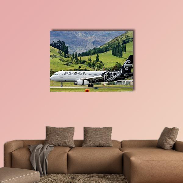 Airplane at Queenstown Airport Canvas Wall Art in white, green and blue, single panel hung on a wall