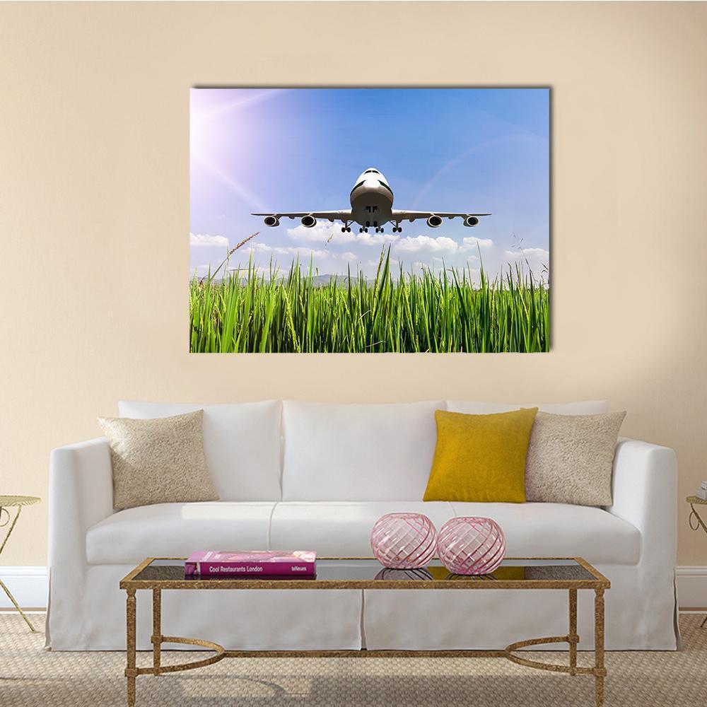Commercial Airplane Over Blue Sky and Rice Fields Canvas Wall Art in green and blue, single panel hung on a wall