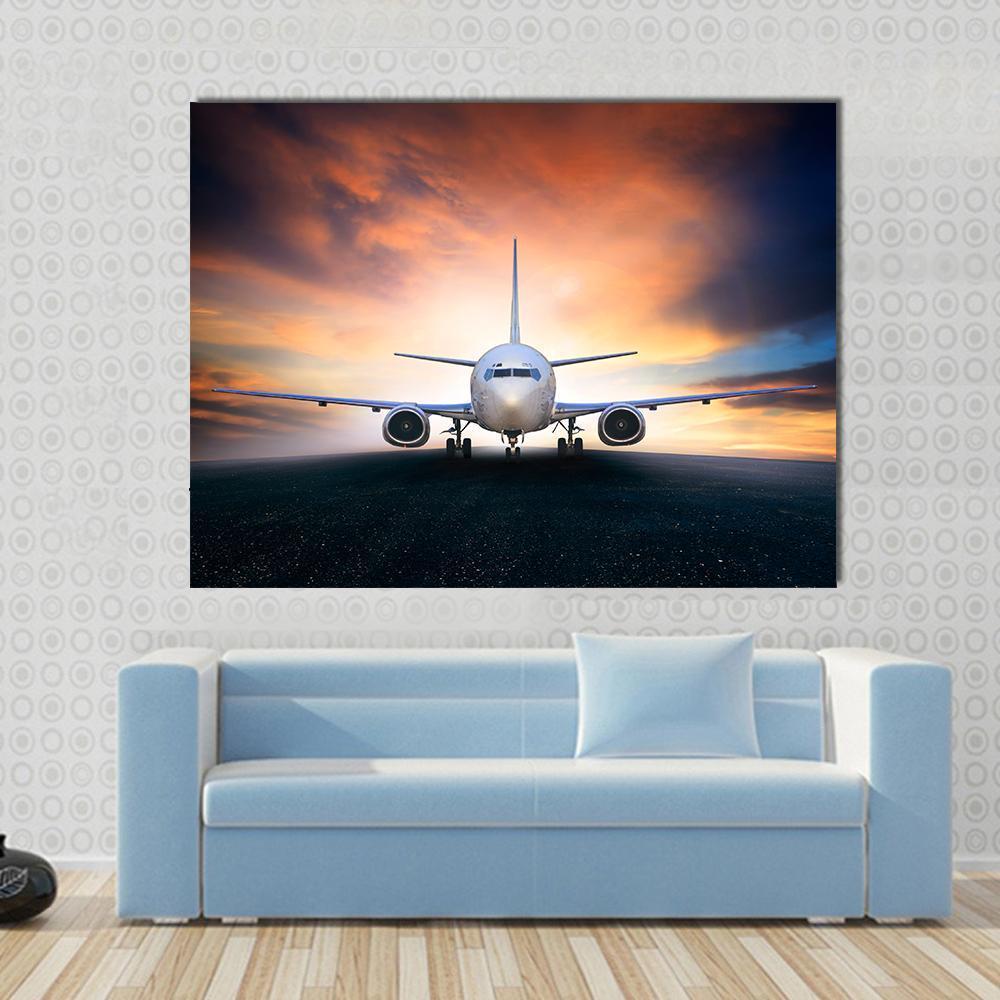 Airplane on Runway Canvas Wall Art in black, orange and blue, single panel hung on a wall