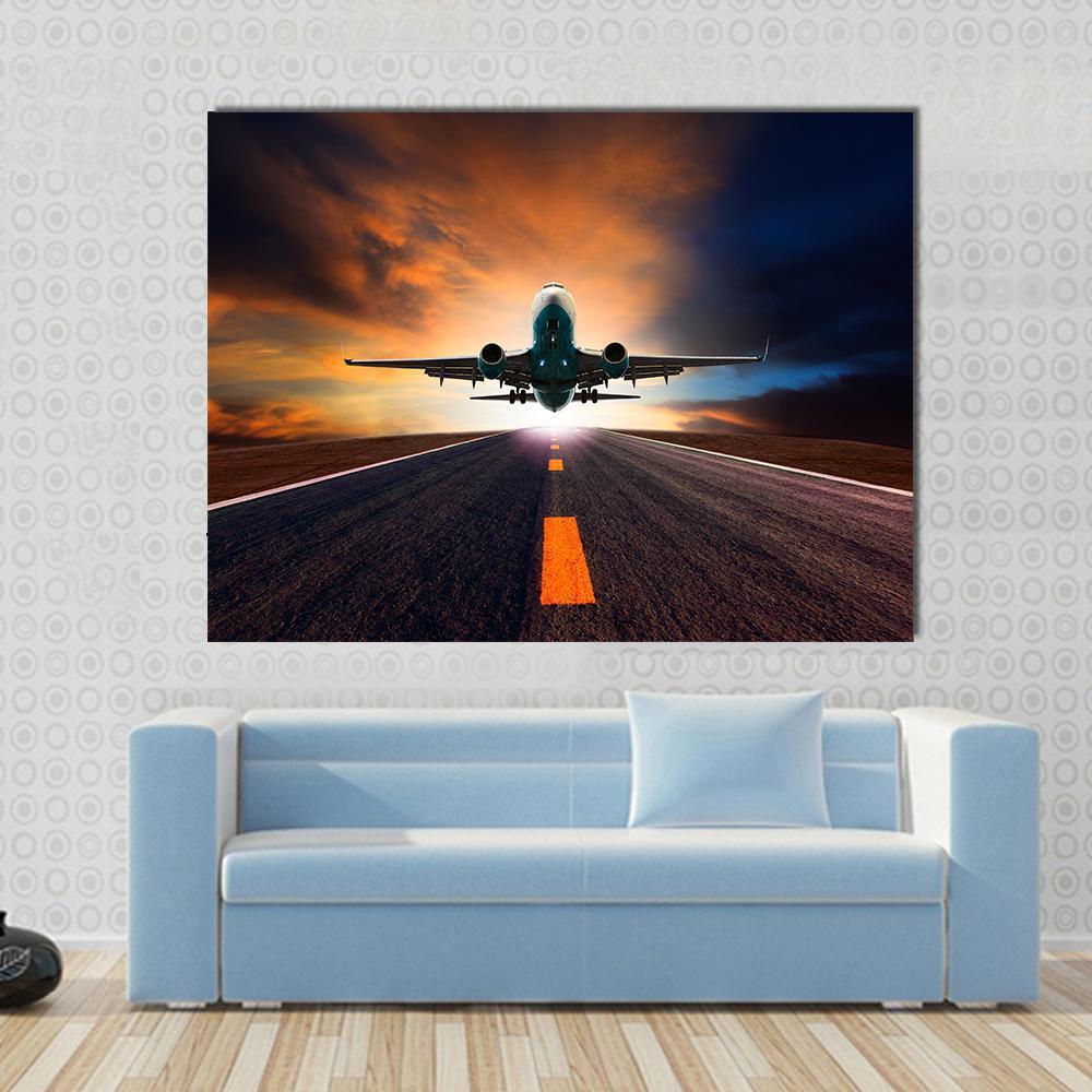 Airplane Taking Off from Runway Canvas Wall Art in black, orange and blue, single panel hung on a wall