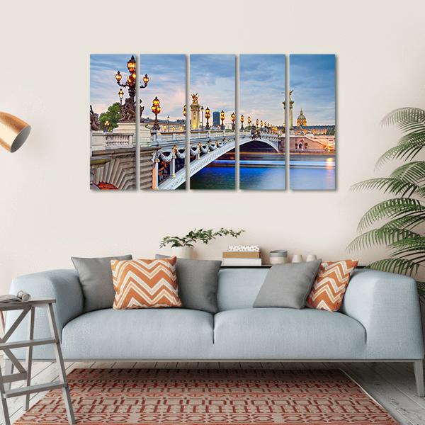 Pont Alexandre Iii at Twilight Canvas Wall Art in gray, orange and blue, hung on a wall