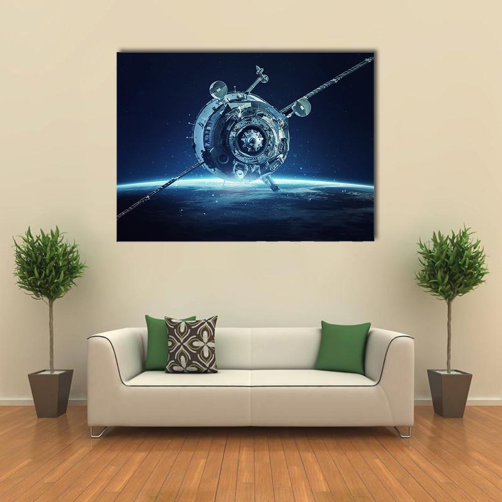 Alien Spacecraft Over Earth Canvas Wall Art in black, silver and blue, single panel hung on a wall