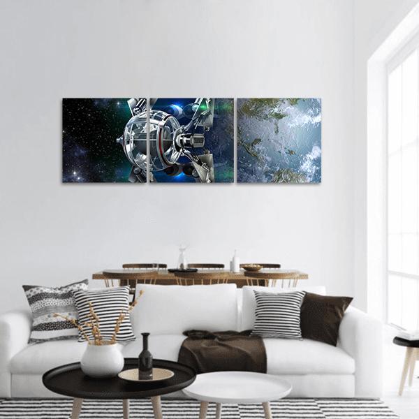 Alien Spaceship Orbiting Earth Panoramic Canvas Wall Art in black, silver and blue, hung on a wall