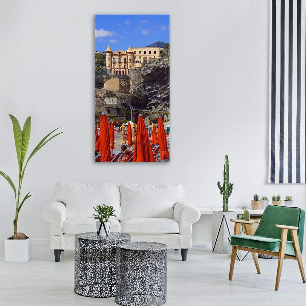 Mediterranean Cliffside Villa with Orange Umbrellas Vertical Canvas Wall Art in beige, orange and blue, single vertical panel hung on a wall