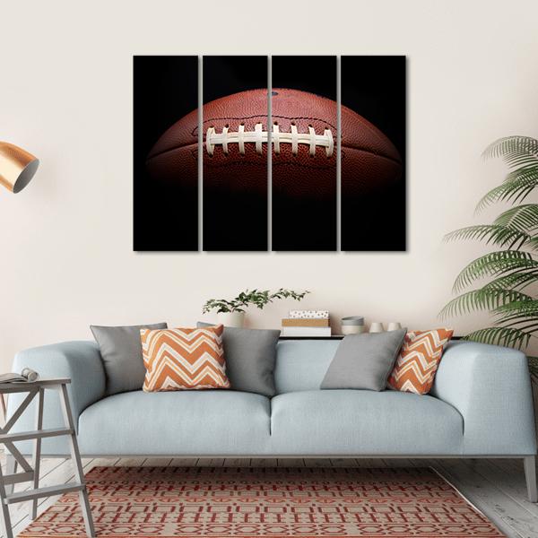American Football Close-up with White Laces Canvas Wall Art in black and brown, hung on a wall