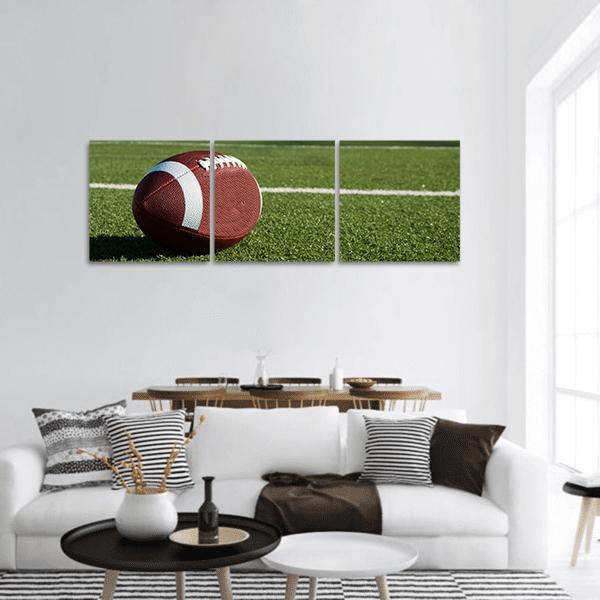 American Football on Green Turf Panoramic Canvas Wall Art in white, brown and green, hung on a wall