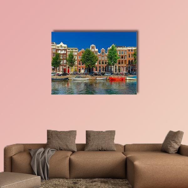 Amsterdam Canal Houses Canvas Wall Art in brown and blue, single panel hung on a wall
