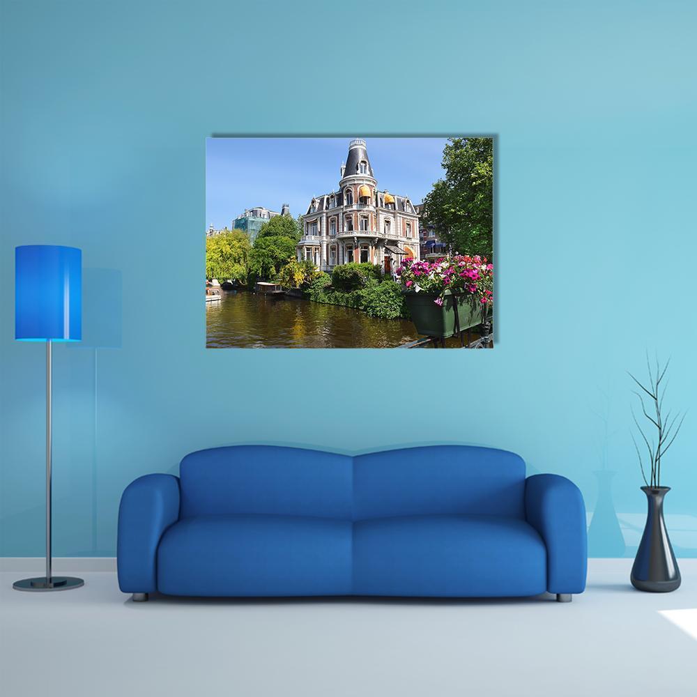 Amsterdam Canal with Boats and Flowers Canvas Wall Art in brown, green and blue, single panel hung on a wall