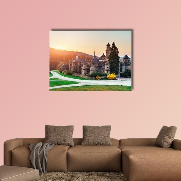 Sunset Over German Stone Castle Canvas Wall Art in orange, yellow and green, single panel hung on a wall