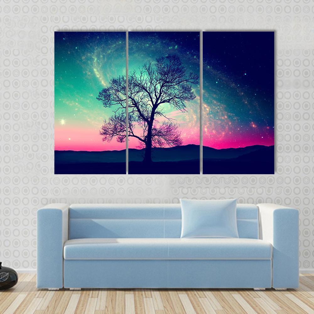 Andromeda Galaxy Over Earth Canvas Wall Art in blue, purple and pink, 3 panel horizontal set hung on a wall