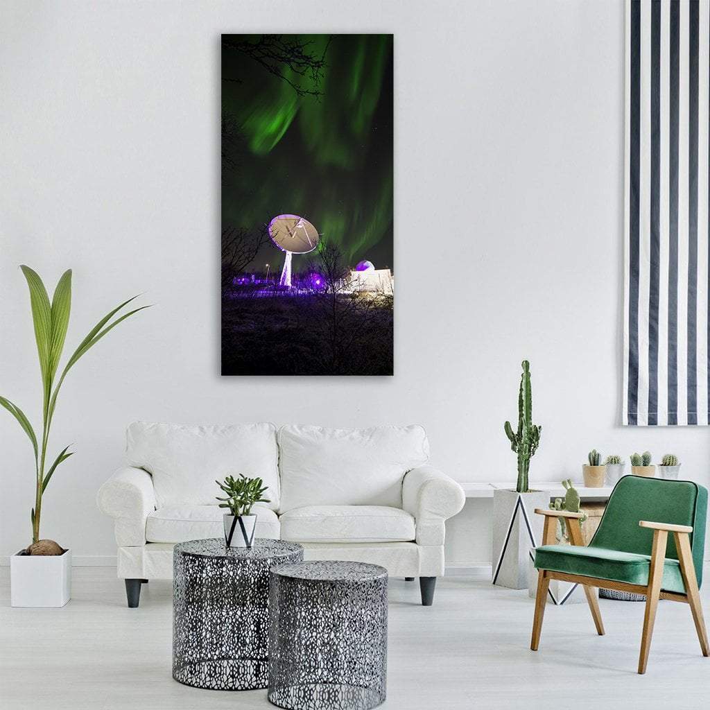 Satellite Dish Under Northern Lights Vertical Canvas Wall Art in black, green and purple, hung on a wall