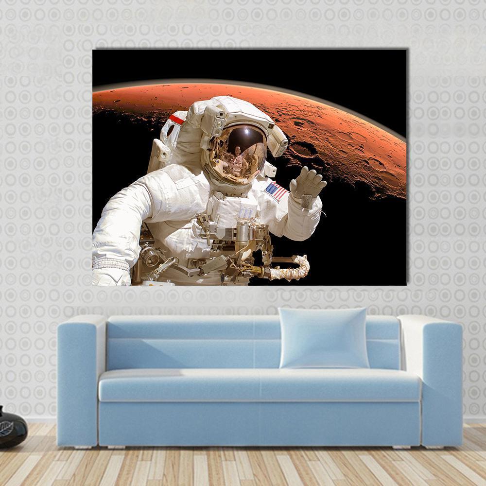 Astronaut Above Mars Canvas Wall Art in black, white and orange, single panel hung on a wall