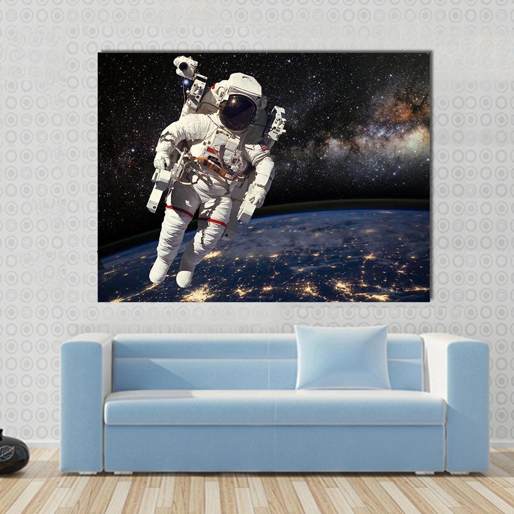 Astronaut and Milky Way Canvas Wall Art in black, white and blue, single panel hung on a wall