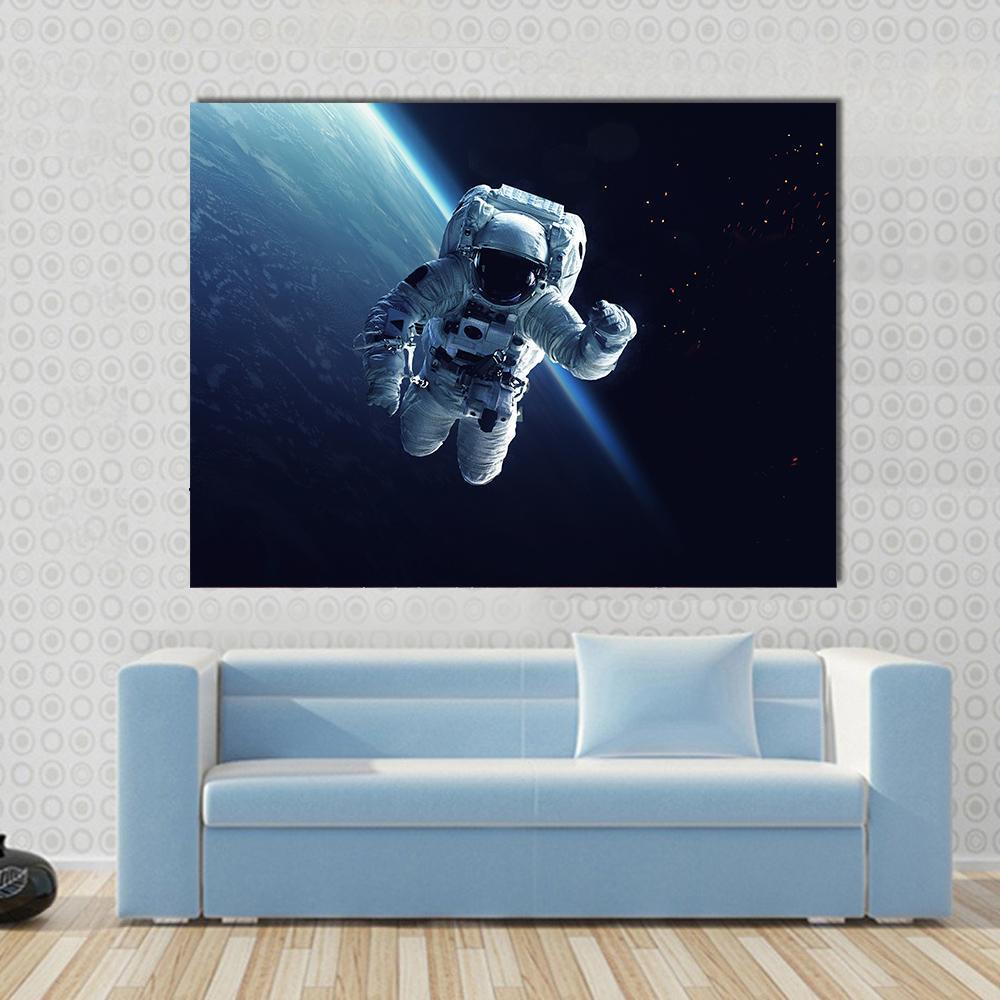 Astronaut in Space Canvas Wall Art in black, white and blue, single panel hung on a wall