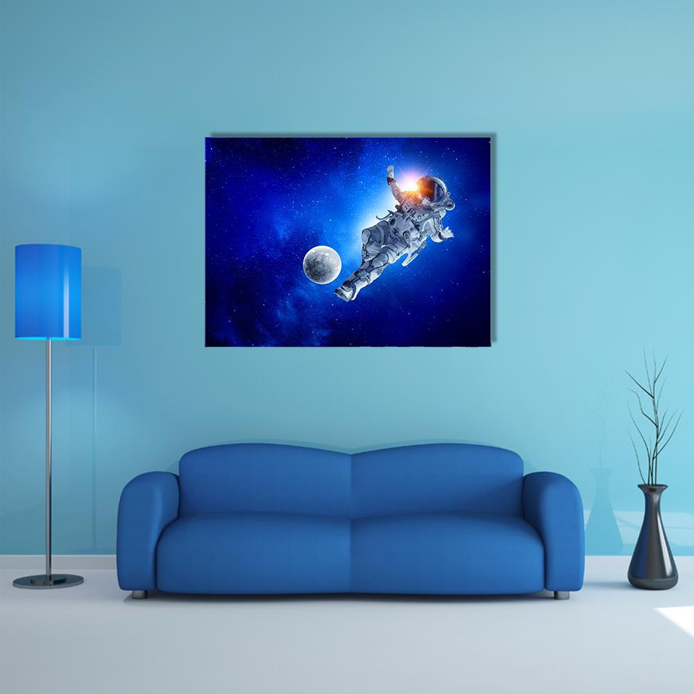 Astronaut Playing Soccer in Space Canvas Wall Art in black, white and blue, single panel hung on a wall