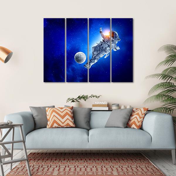 Astronaut Playing Soccer in Space Canvas Wall Art in black, white and blue, hung on a wall
