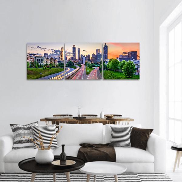 Atlanta Skyline with Light Trails Panoramic Canvas Wall Art in orange, green and blue, hung on a wall