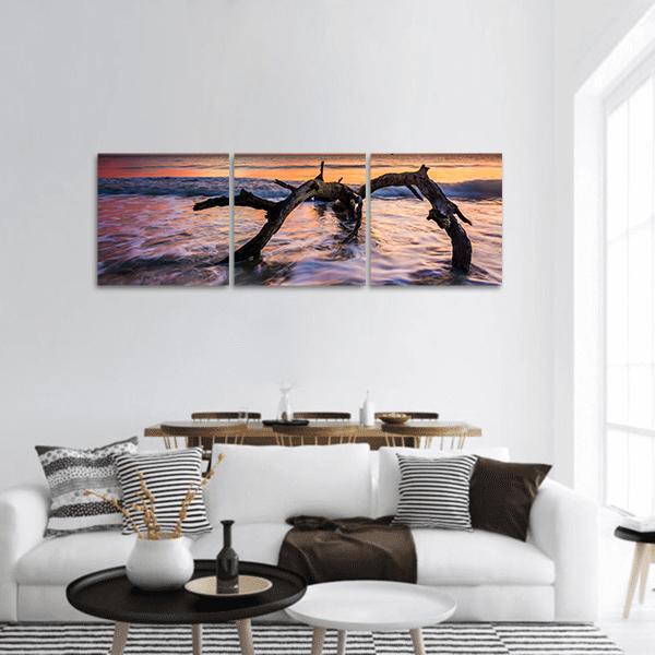 Atlantic Ocean Sunrise with Driftwood Panoramic Canvas Wall Art in orange, blue and purple, hung on a wall