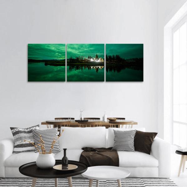 Iceland Aurora Over Lakeside Village Panoramic Canvas Wall Art in black and green, single panel hung on a wall