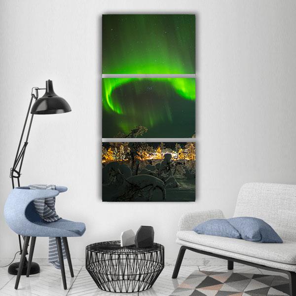 Aurora Borealis Over Snow-covered Trees Vertical Canvas Wall Art in black and green, single vertical panel hung on a wall
