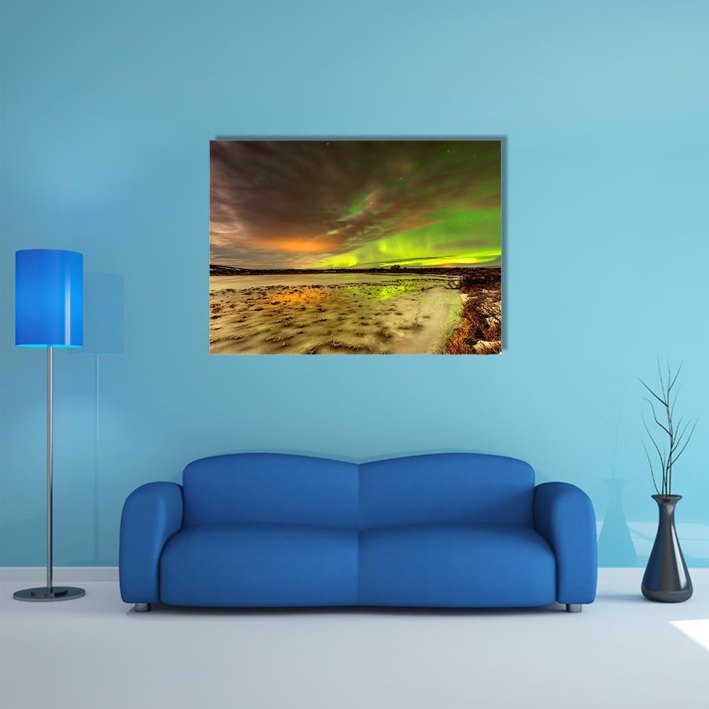 Aurora Borealis Over Frozen Lake Canvas Wall Art in gray, yellow and green, single panel hung on a wall