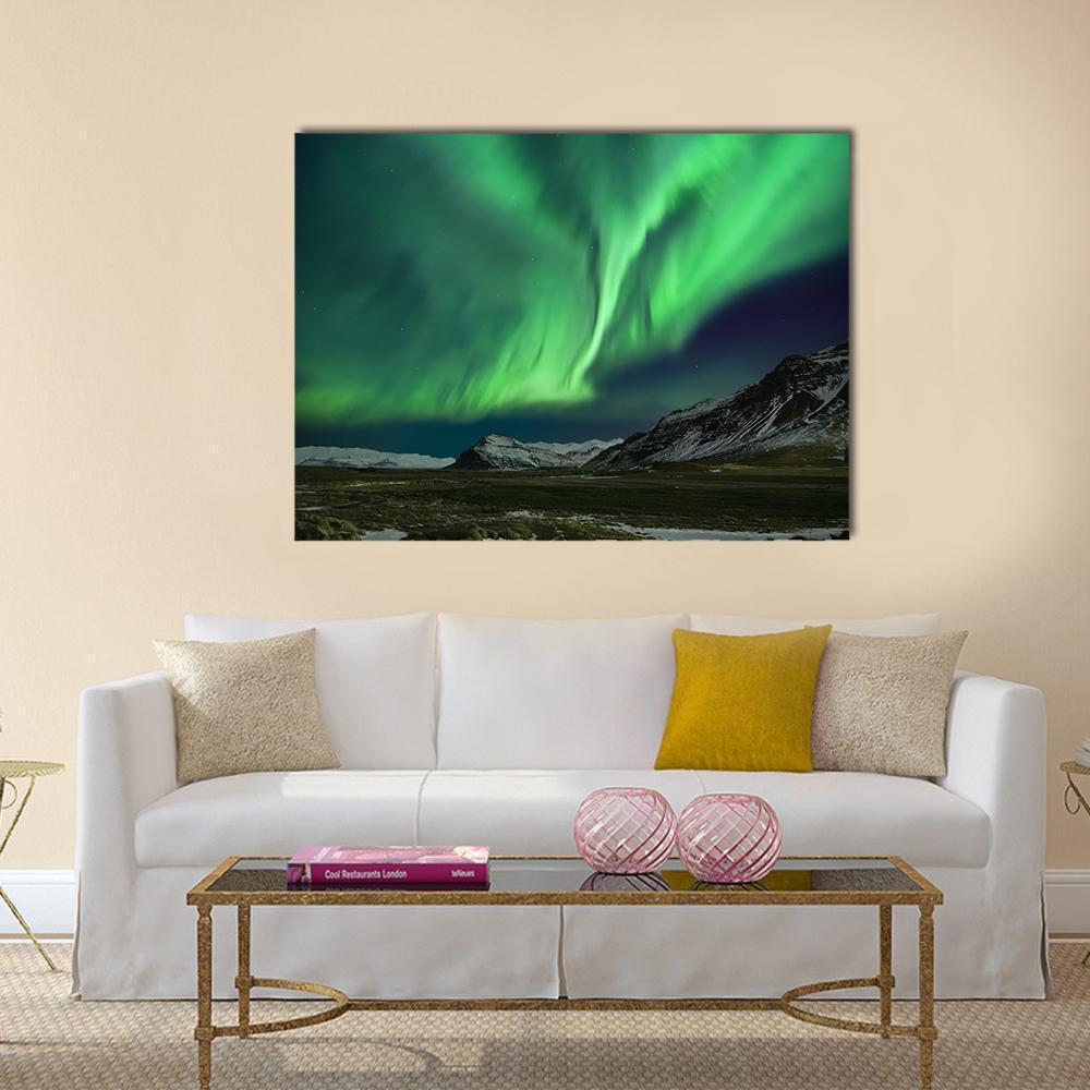 Aurora Polaris Over Snow-capped Mountains Canvas Wall Art in black and green, single panel hung on a wall