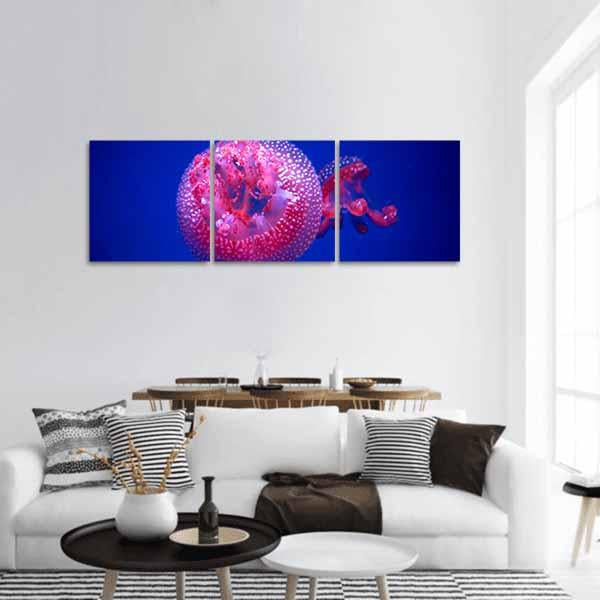 Australian Spotted Jellyfish in Deep Blue Panoramic Canvas Wall Art in blue, purple and pink, hung on a wall