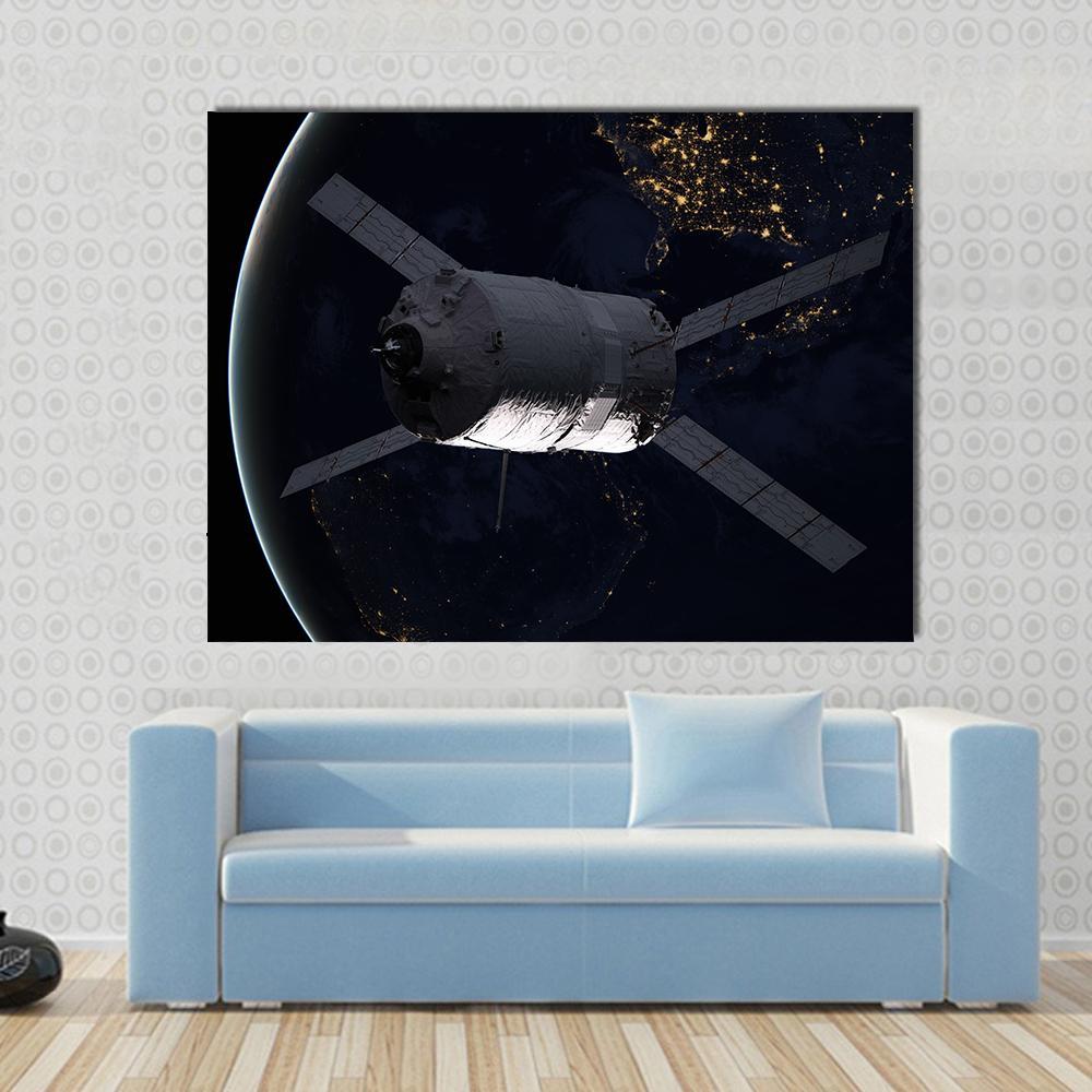 Spacecraft Over Earth at Night Canvas Wall Art in black, silver and blue, single panel hung on a wall