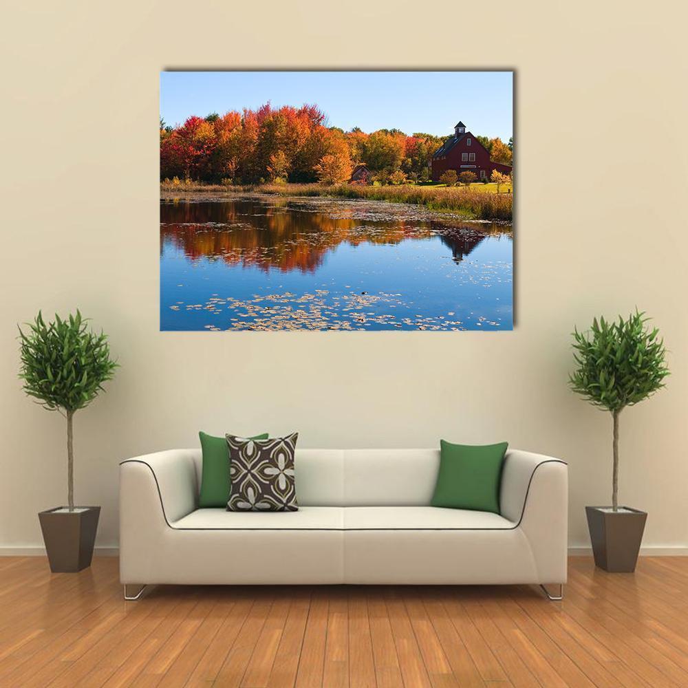 Red Barn Reflected in Autumn Pond Canvas Wall Art in red, orange and blue, single panel hung on a wall