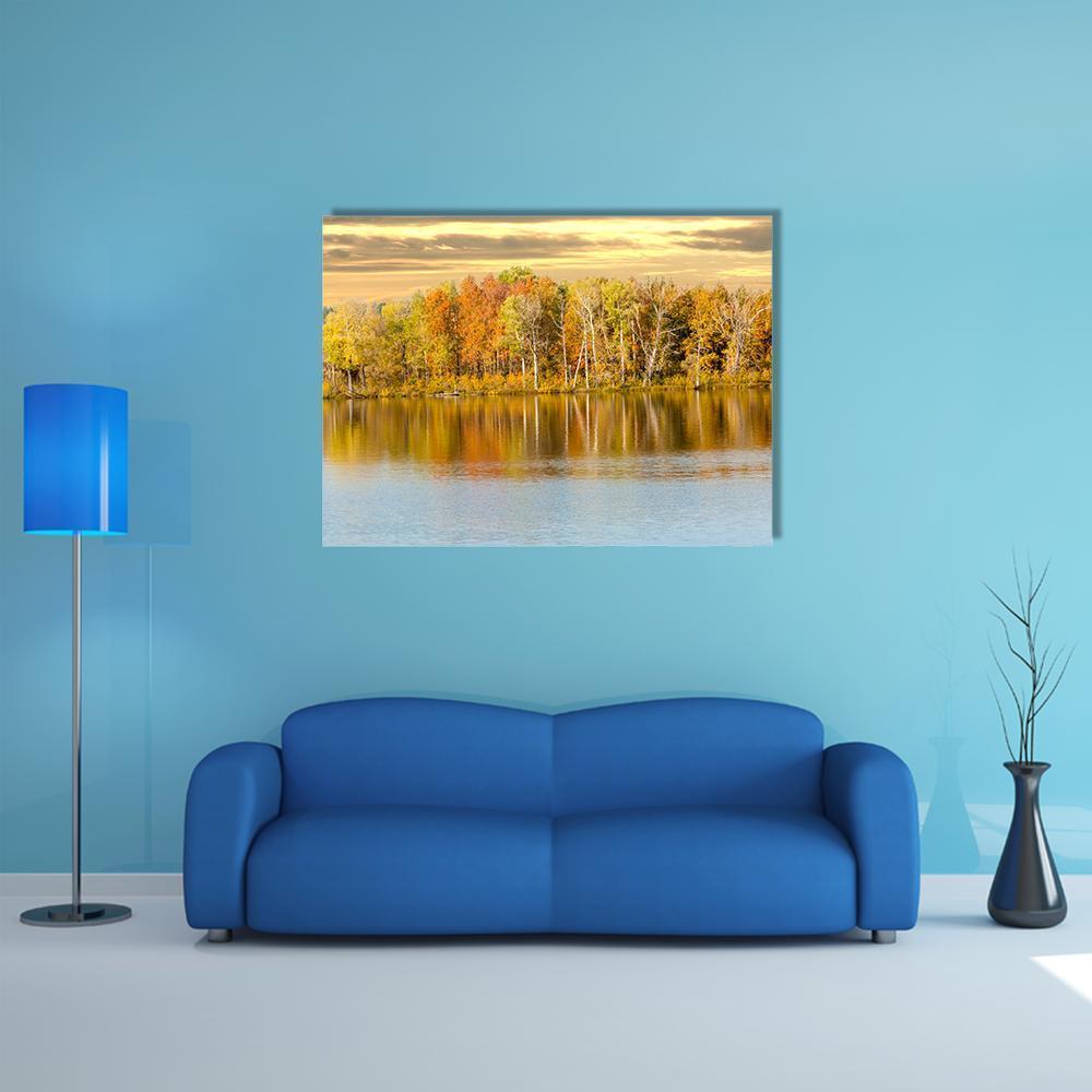 Autumn Forest by a Calm Lake Canvas Wall Art in orange, yellow and blue, single panel hung on a wall