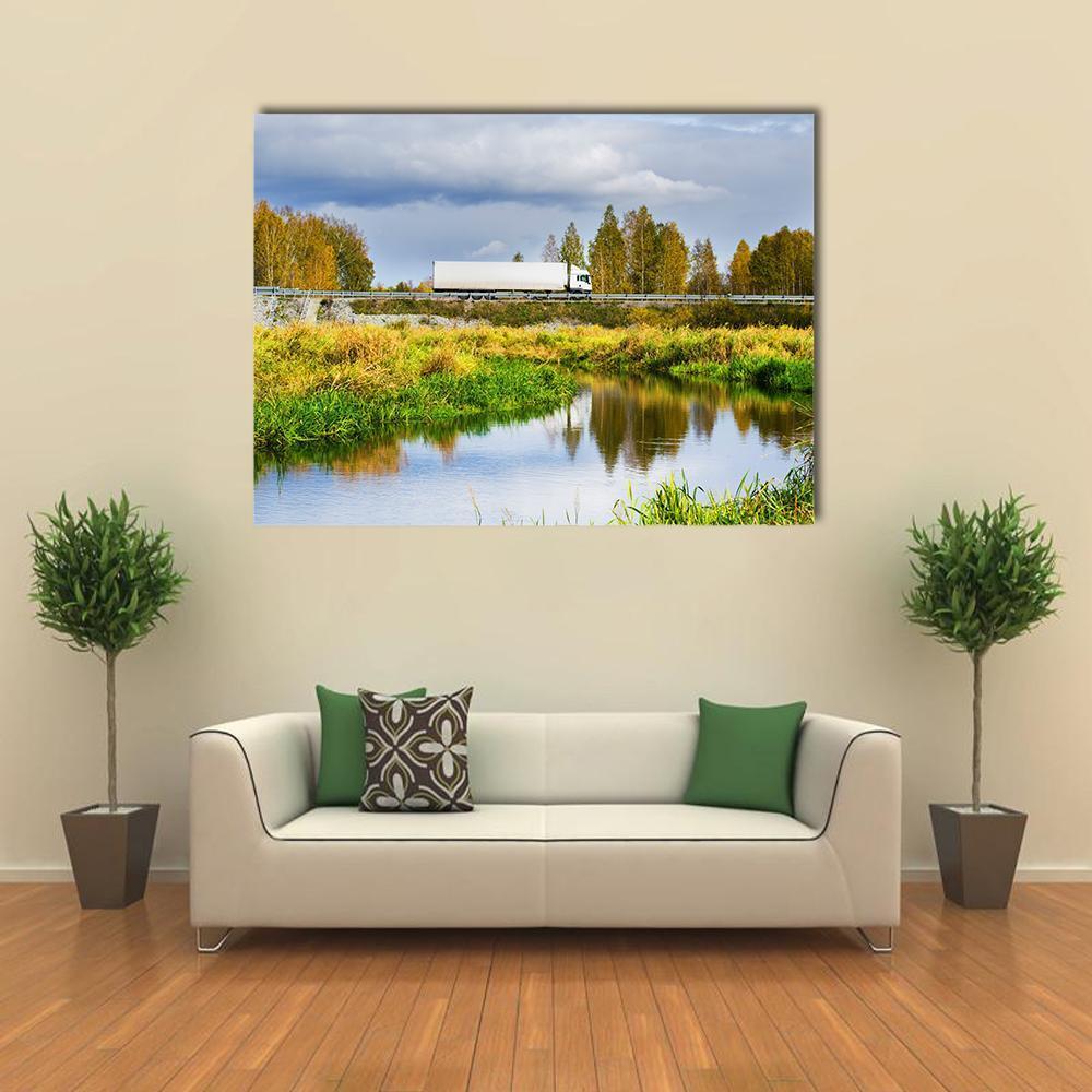Autumn Overpass with Truck and River Canvas Wall Art in yellow, green and blue, single panel hung on a wall