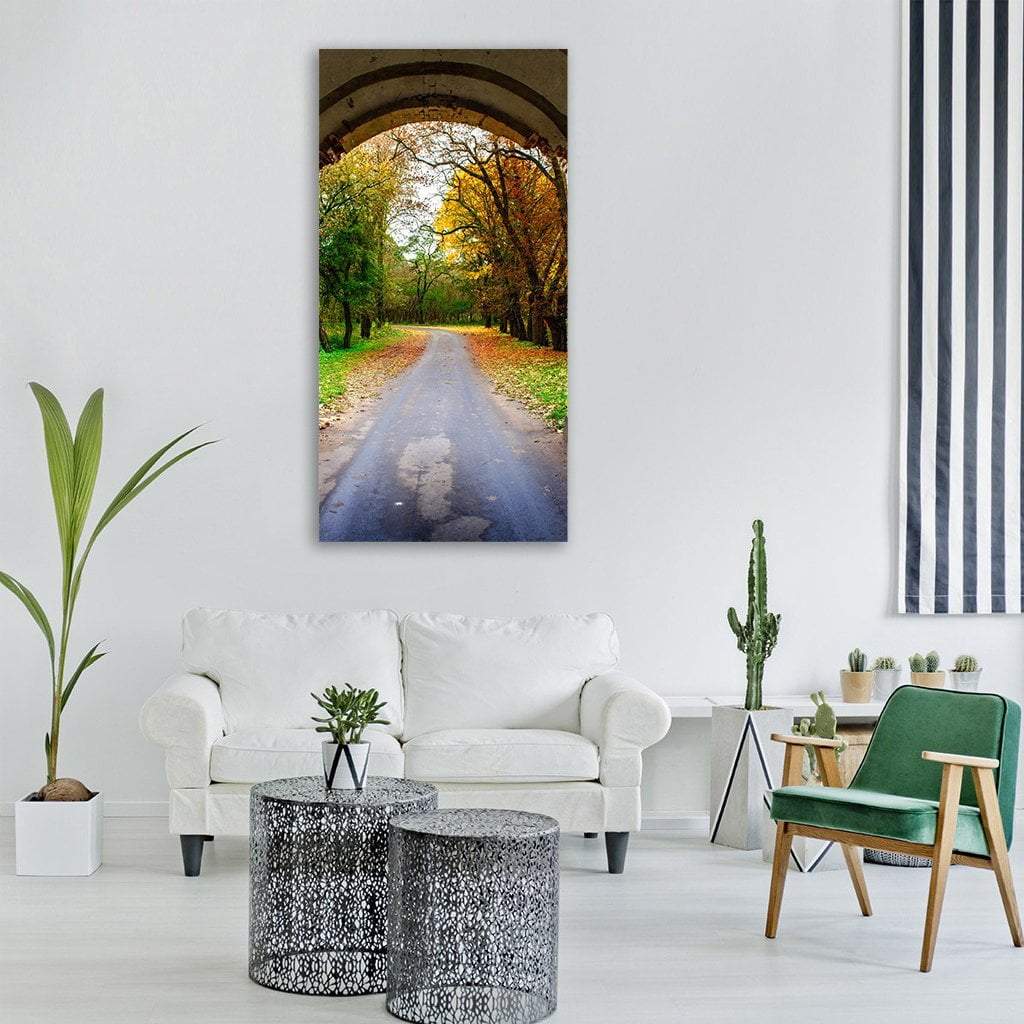 Autumn Pathway Through Archway Vertical Canvas Wall Art in gray, orange and green, single vertical panel hung on a wall