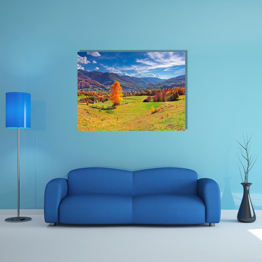Autumn Mountain Village Canvas Wall Art in orange, green and blue, single panel hung on a wall