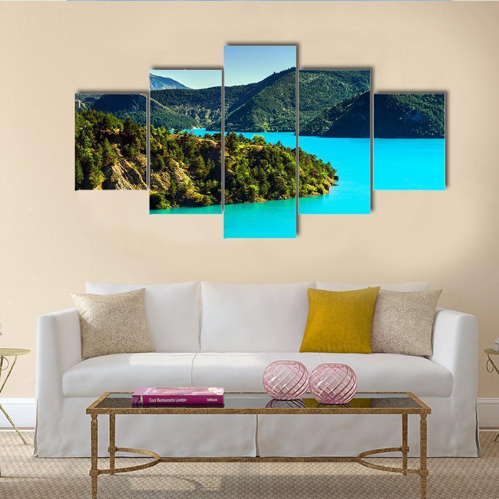 Turquoise Lake with Mountain Shore Canvas Wall Art in brown, green and blue, 5 panel Star layout hung on a wall