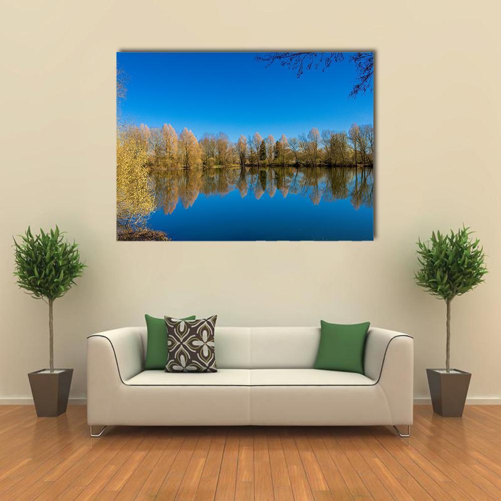 Barnwell Country Park Lake Reflection Canvas Wall Art in brown, yellow and blue, single panel hung on a wall