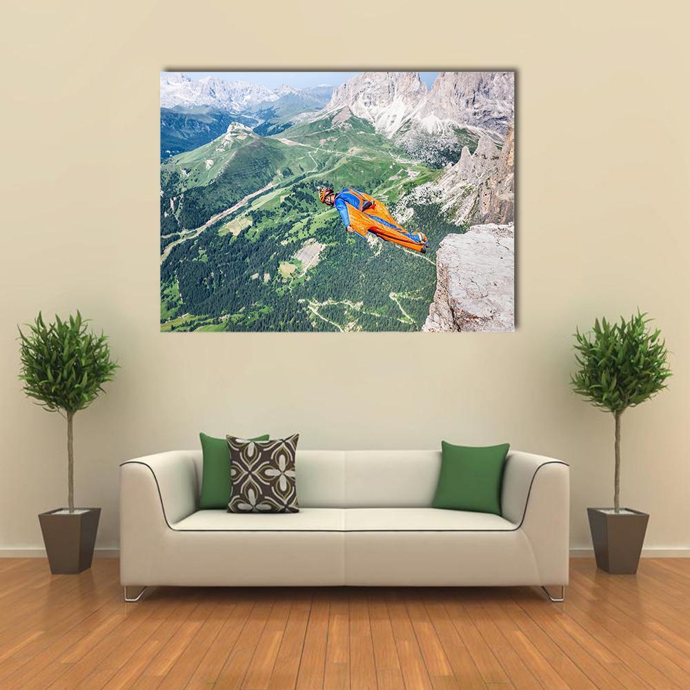 Base Jumper Leaping from Steep Cliff Canvas Wall Art in gray, green and blue, single panel hung on a wall