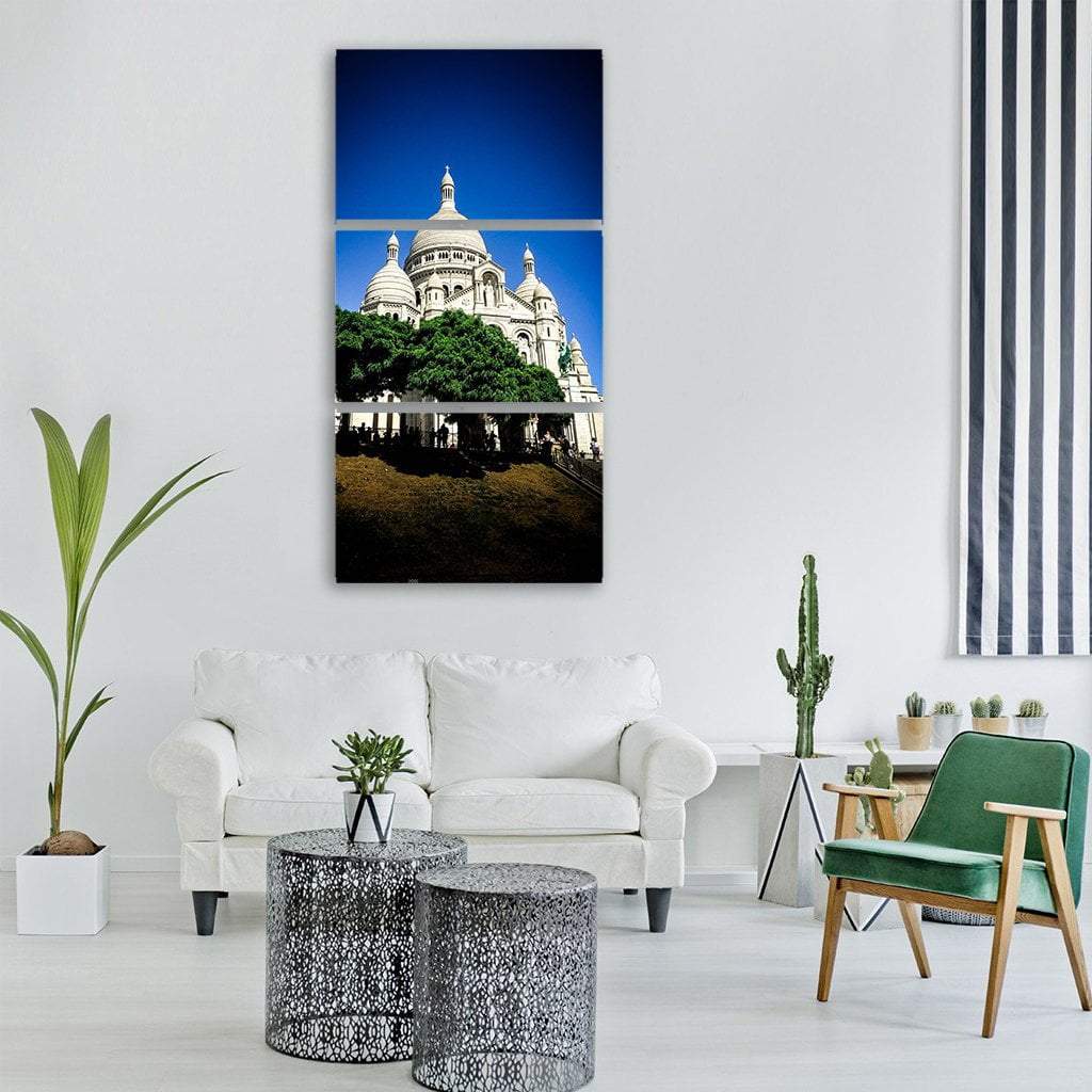 Sacré-cœur Basilica on Grassy Hill Vertical Canvas Wall Art in white, green and blue, hung on a wall