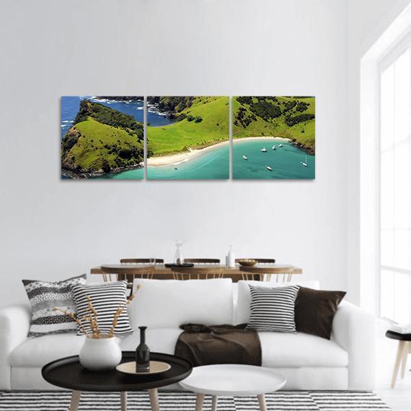 Turquoise Bay and Lush Green Headland Panoramic Canvas Wall Art in green and blue, hung on a wall