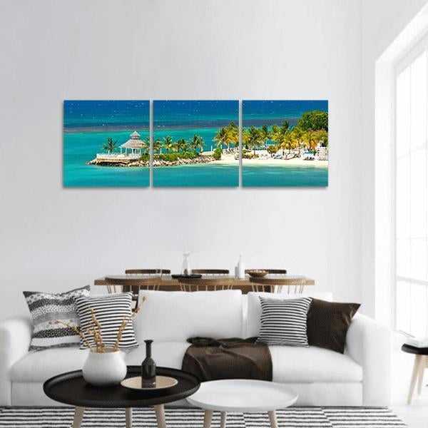 Tropical Beach with White Gazebo Panoramic Canvas Wall Art in white, green and blue, hung on a wall