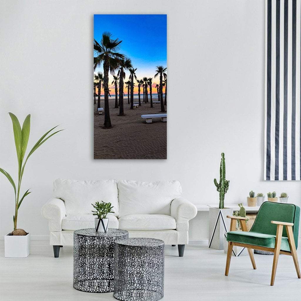 Silhouetted Palms at Sunset Beach Vertical Canvas Wall Art in black, orange and blue, single vertical panel hung on a wall