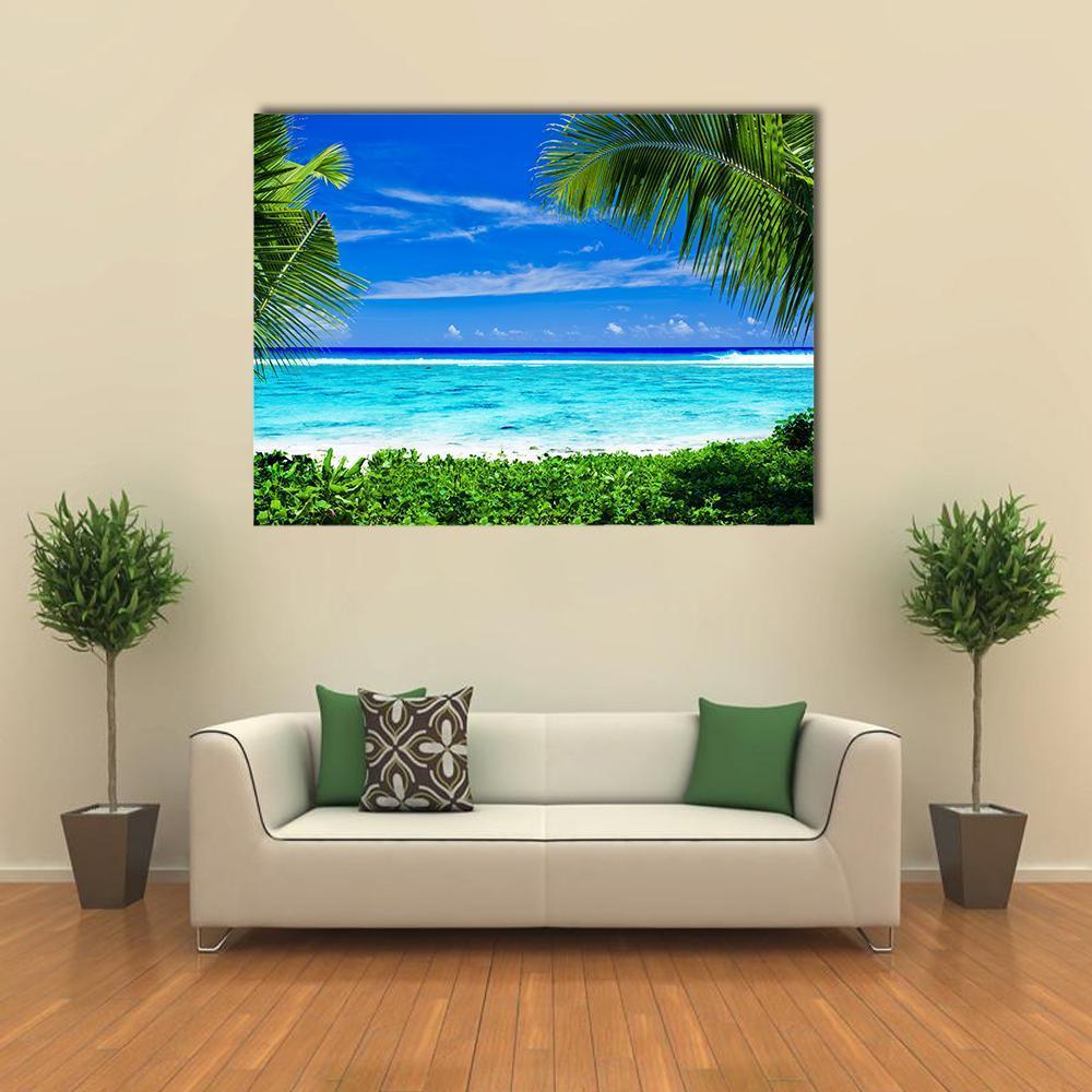 Tropical Lagoon with Palm Trees Canvas Wall Art in green and blue, single panel hung on a wall