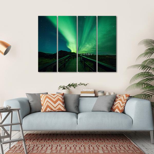 Aurora Borealis Over Iceland Boardwalk Canvas Wall Art in black and green, hung on a wall