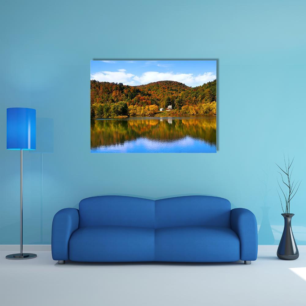 Autumn Lake with Forest Reflection Canvas Wall Art in orange, yellow and blue, single panel hung on a wall