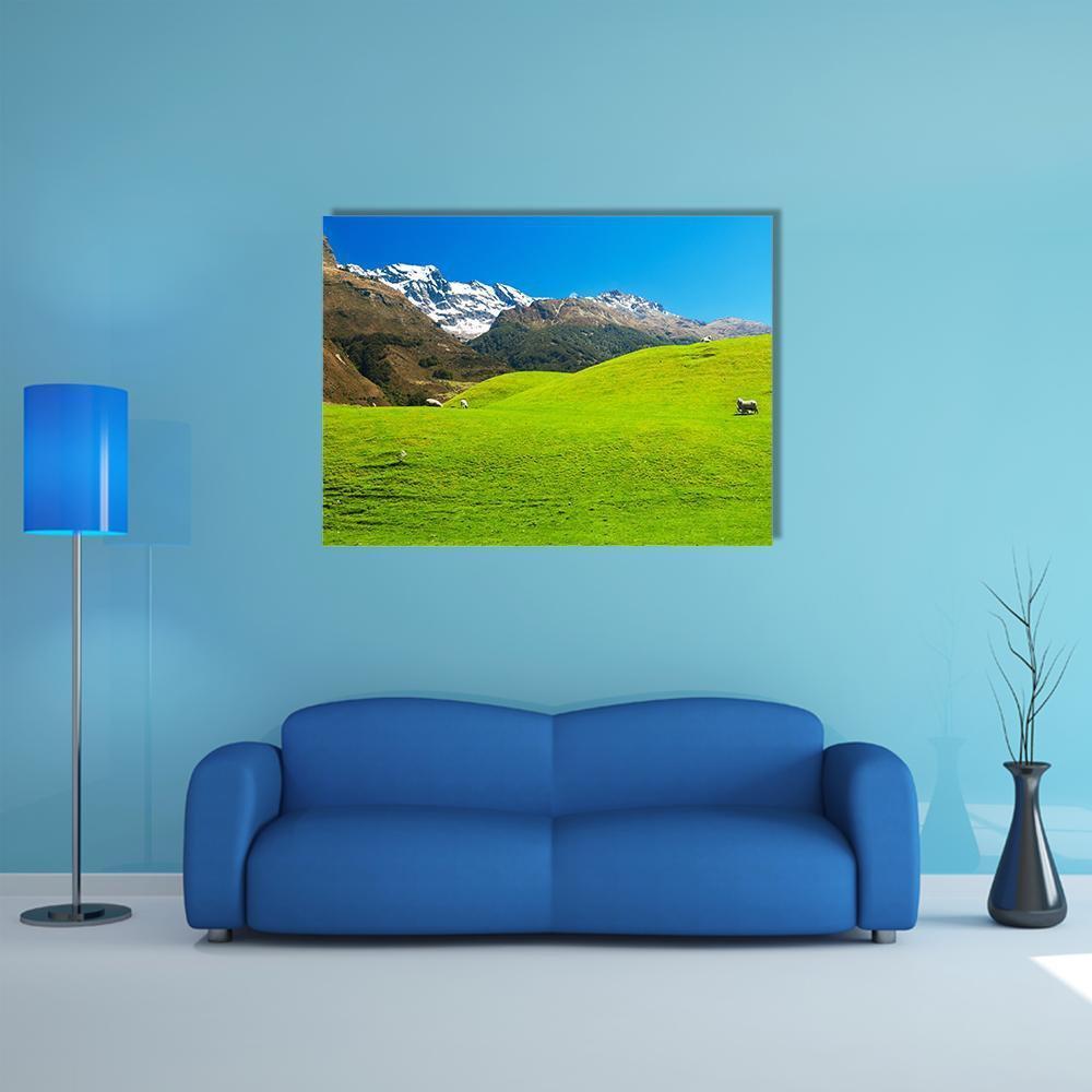 New Zealand Hills with Sheep and Snowy Peaks Canvas Wall Art in brown, green and blue, single panel hung on a wall
