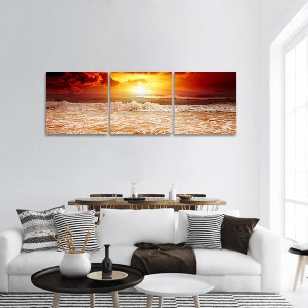Sunset Above the Sea Panoramic Canvas Wall Art in red, orange and yellow, hung on a wall